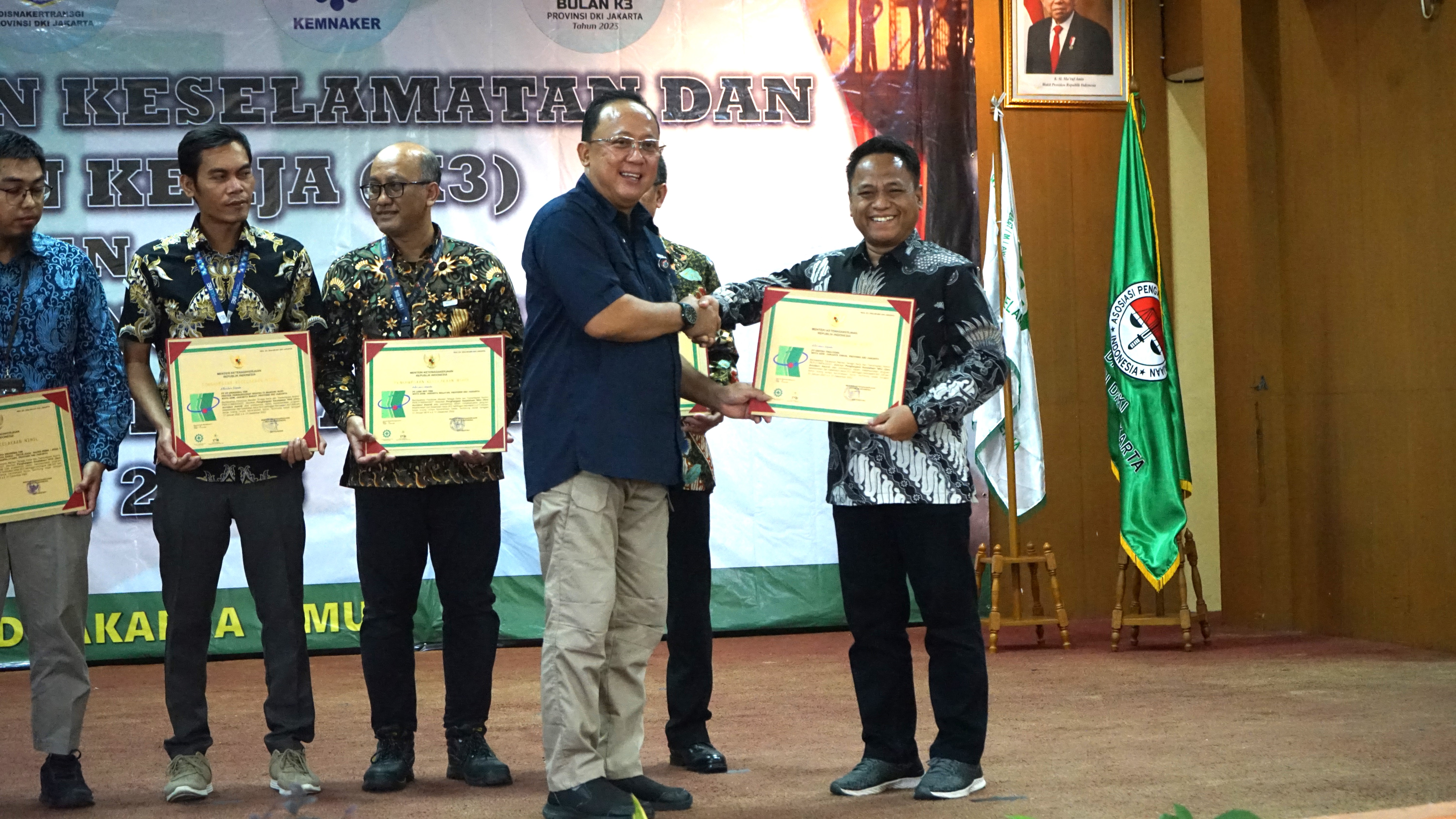 The award presentation from Dr. Ir. Hari Nugroho (Head of the DKI Jakarta Province Manpower, Transmigration and Energy Agency) to UT's representative, Furkon (EHS Team Member) at the East Jakarta Regional Job Training Center (PPKD).